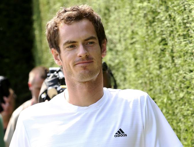 Un sorridente e riposato Andy Murray torna sull'erba di Wimbledon per l'allenamento del sabato dopo il successo in semifinale contro il polacco Jerzy Janowicz. Reuters